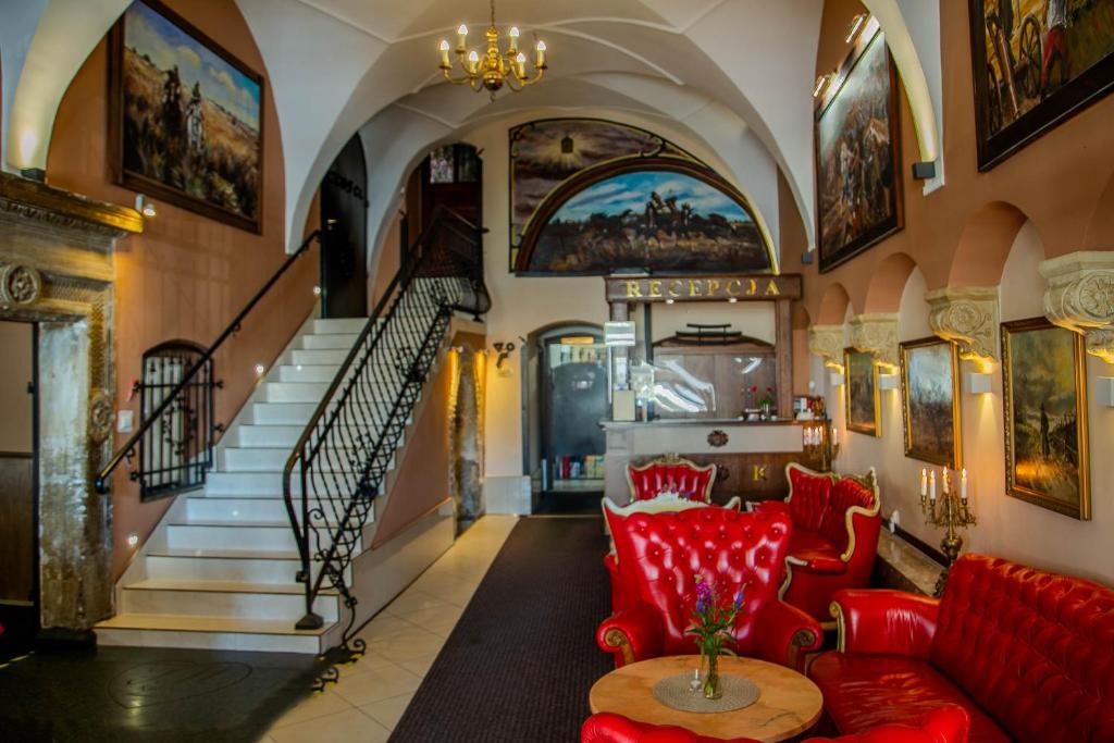 una sala de estar con muebles de color rojo y una escalera en Euro Aparthotel, en Tarnów