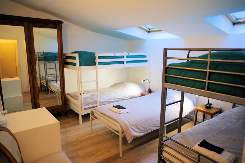 Cette chambre comprend 2 lits superposés et un miroir. dans l'établissement Maison de charme au Mont Valérien avec jardin privatif, à Nanterre