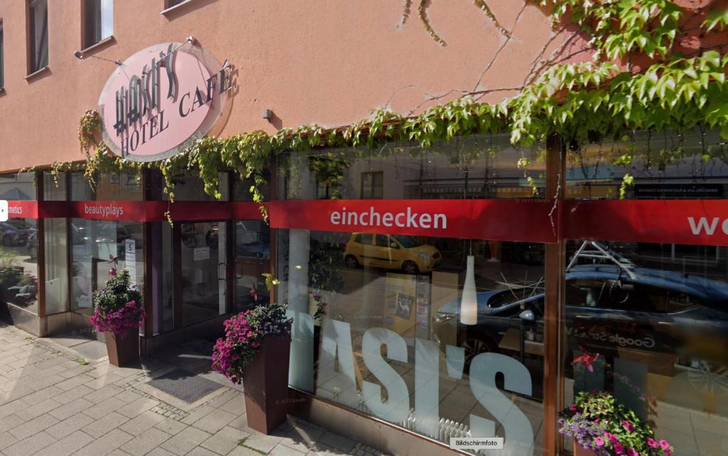 a store with a sign on the side of a building at Hasi's Hotel in Grafing