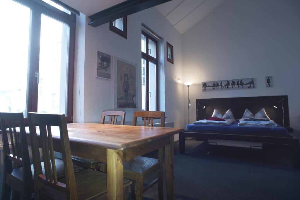 een eetkamer met een tafel en een bed bij Pension Mädchenkammer in Berlijn