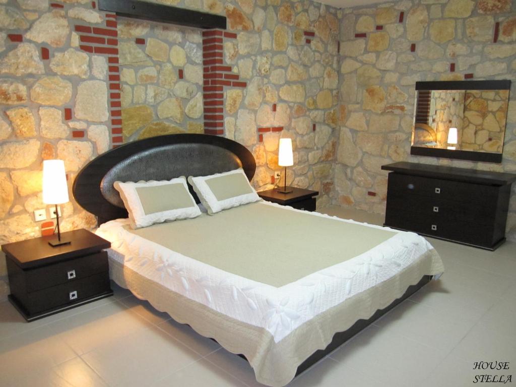 een slaapkamer met een groot bed en een stenen muur bij Psakoudia Villas in Psakoudia