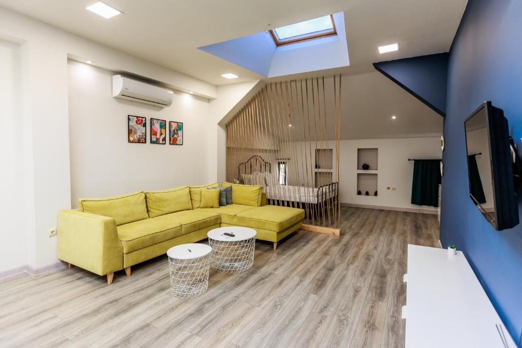 een woonkamer met een gele bank en een tv bij B3 Delux Studio Saffron in Plovdiv