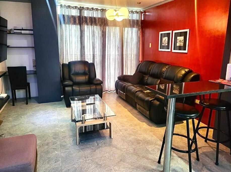 uma sala de estar com um sofá de couro e uma mesa em Kandi Modern 1BR, king bed. Wi-Fi, housekeeping! em Angeles