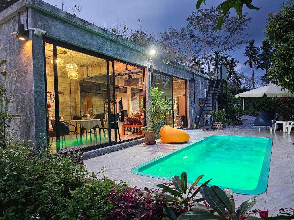 una piscina frente a una casa en The Box Promkiri (เดอะบ๊อค พรหมคีรี) en Ban Pak Ram