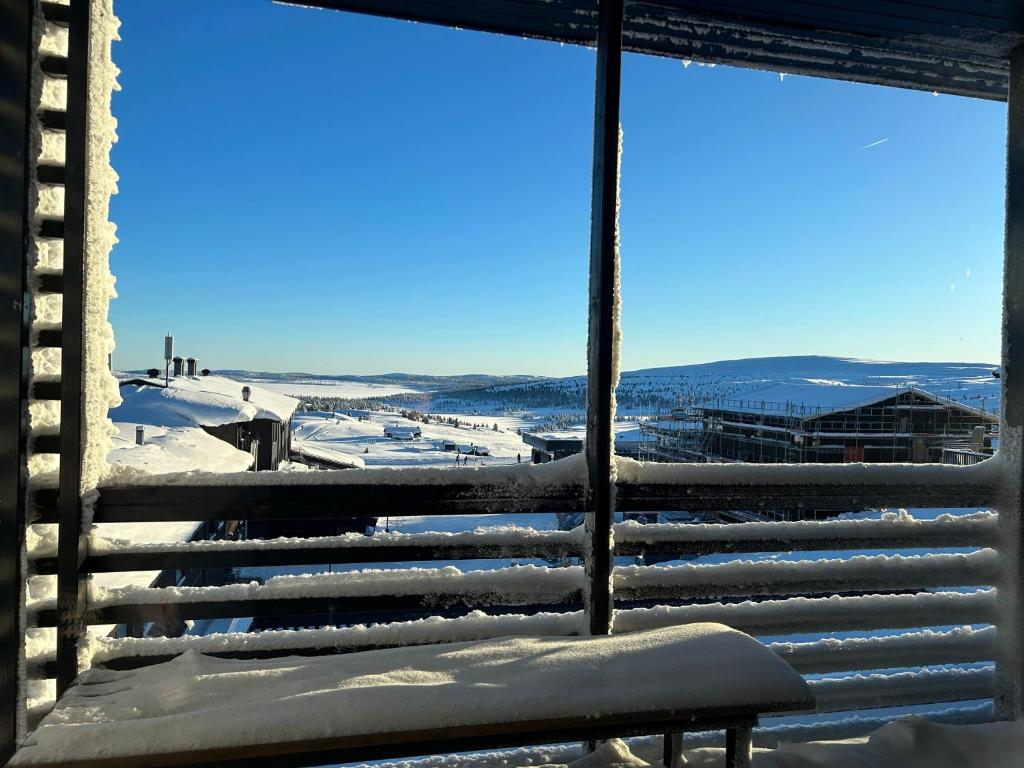 un banco sentado en la parte superior de un edificio cubierto de nieve en Pellestova Apartments, en Hafjell