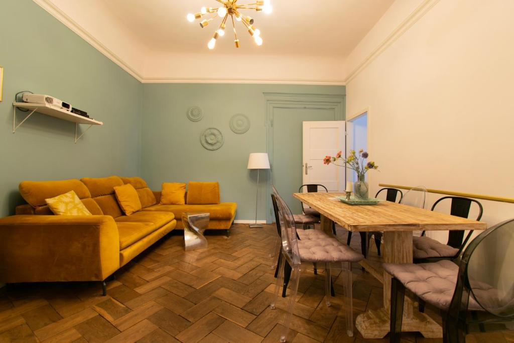 ein Wohnzimmer mit einem gelben Sofa und einem Tisch in der Unterkunft Cozy Apartments Krakowska Street, Kazimierz District in Krakau