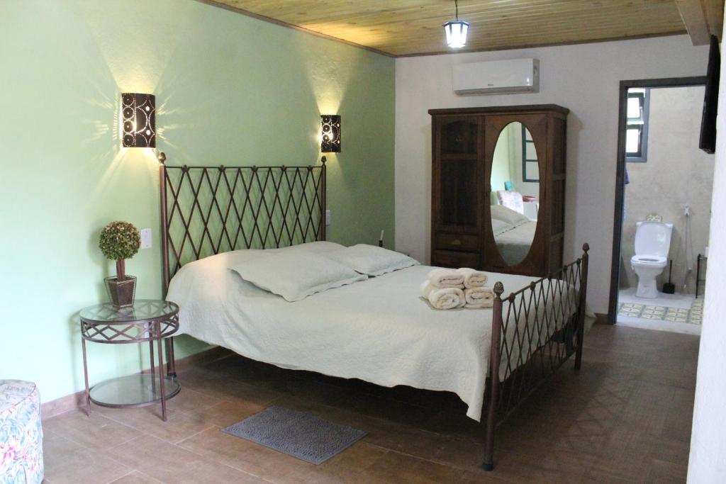 a bedroom with a bed with a mirror and a toilet at Fazenda Dos Coqueiros-Bananal-SP in Bananal