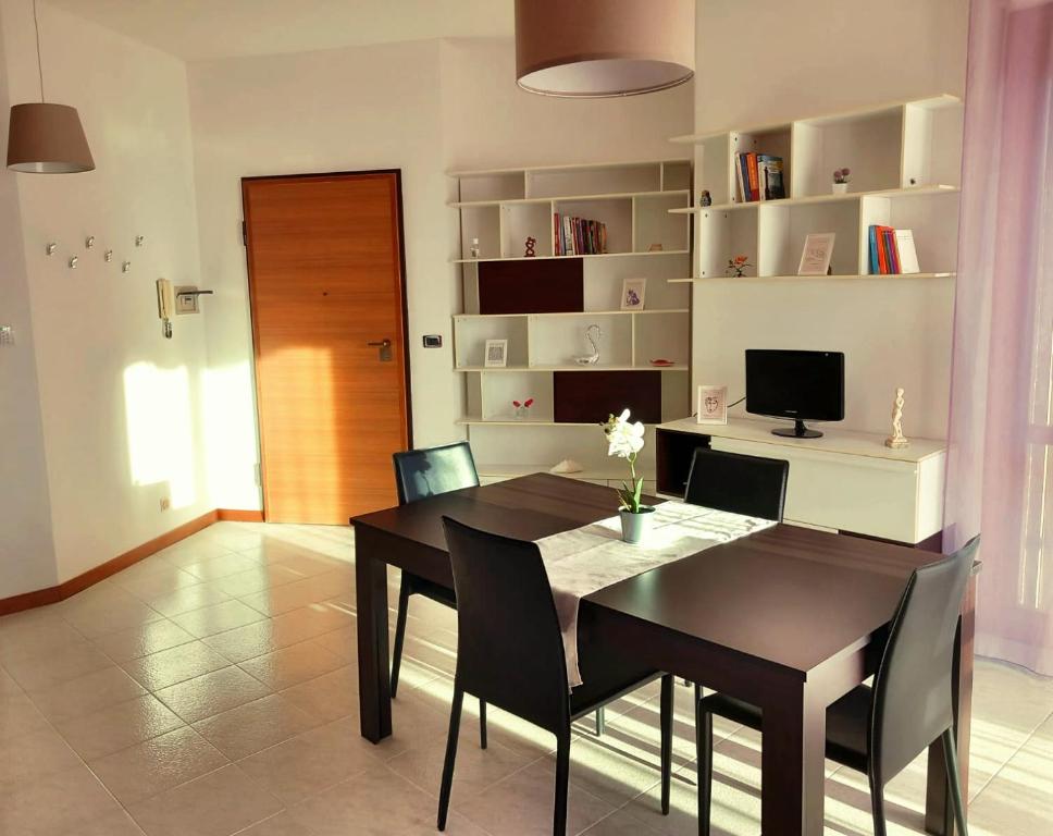 ein Esszimmer mit einem schwarzen Tisch und Stühlen in der Unterkunft la Dolce Vita - Appartamento con parcheggio privato vicino al centro e all'ospedale in Asti