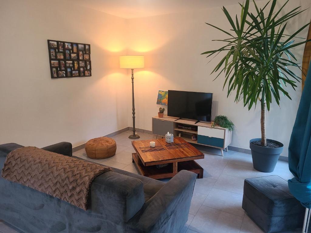 a living room with a couch and a table at Maison cozy - Proche de la Cale de Taden in Taden