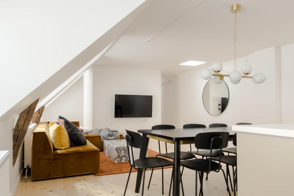 een eetkamer en een woonkamer met een tafel en stoelen bij Central City Flats on Best Location by Round Tower in Kopenhagen