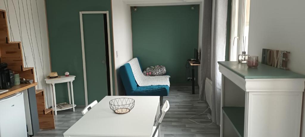een keuken met een witte tafel en een blauwe stoel bij Maison de ville - vue sur la Sainte Baume in Aubagne