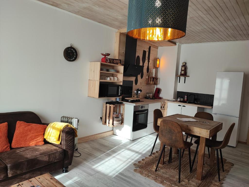 a living room with a couch and a table and a kitchen at Appartement Chez Marie et Aymeric in Bages