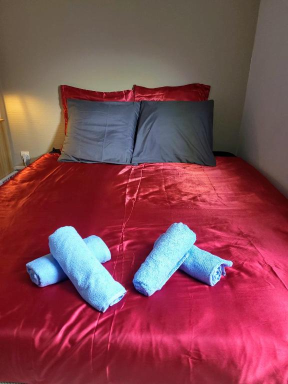 2 toallas azules en una cama roja en Chambre d'Hôtes calme et cosy, à 3min de la gare, centre ville, avec un lit de 160cm, en Nevers