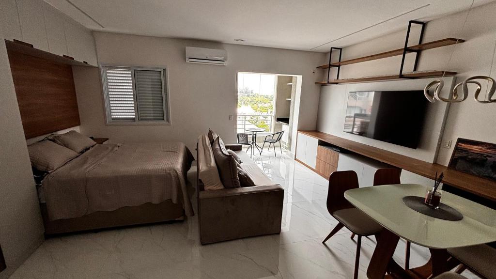 a bedroom with a bed and a table and a dining room at Apartamento Studio em São Bernardo in São Bernardo do Campo