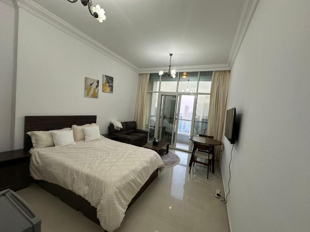 a bedroom with a bed and a living room at Cozy Private Studio APT in Al Mamzar Sharjah in Sharjah