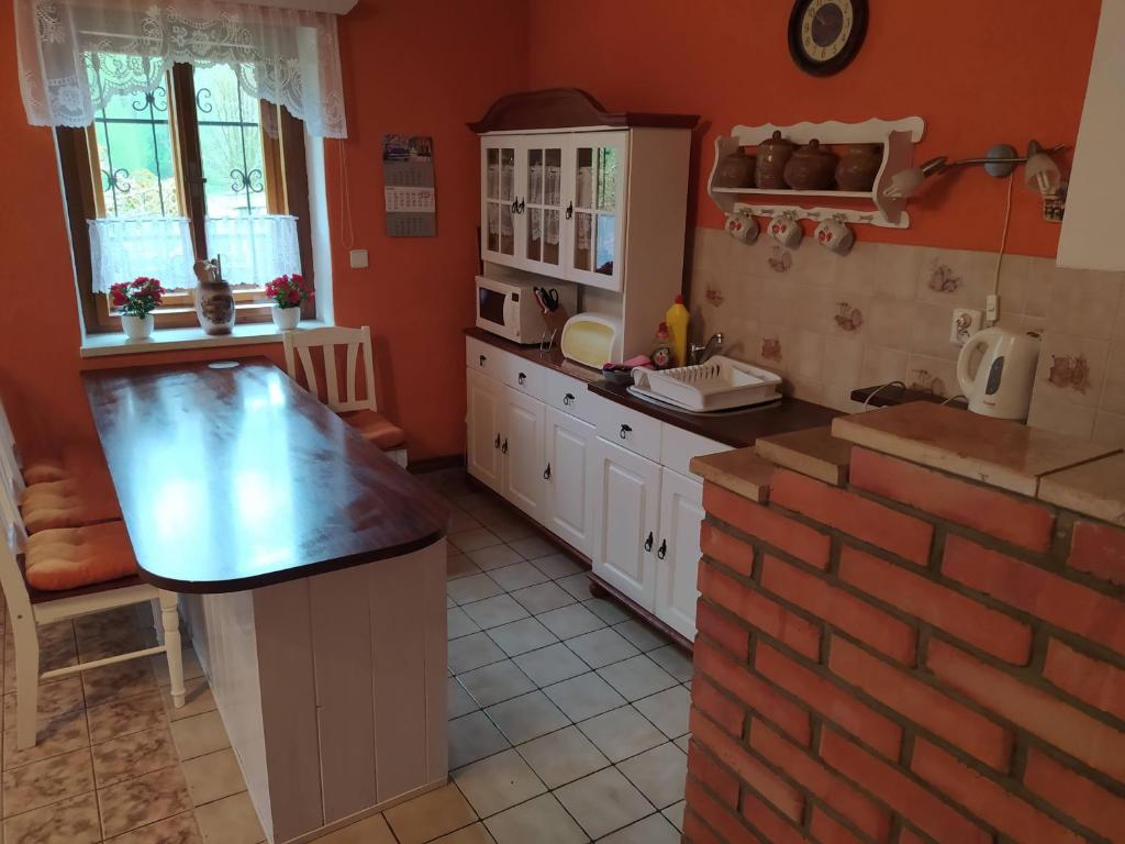 eine Küche mit weißen Schränken und einer Ziegelwand in der Unterkunft Chata Naděje in Raspenava