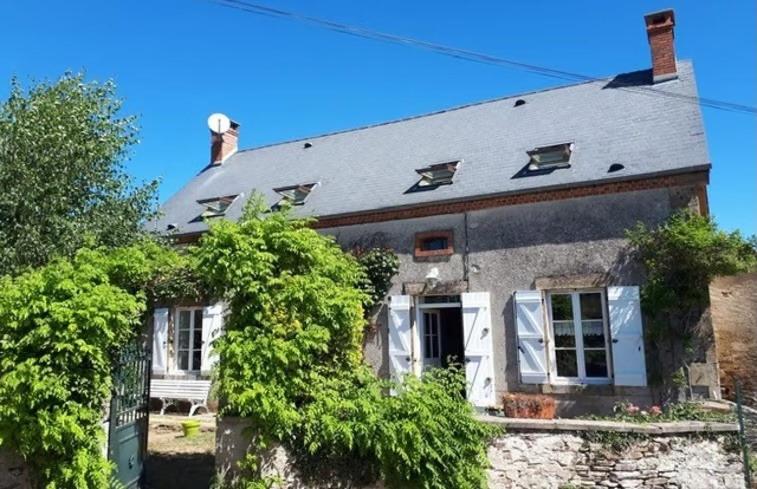 ein altes Steinhaus mit Efeu um sich herum in der Unterkunft La Tour du Boueix in Préveranges