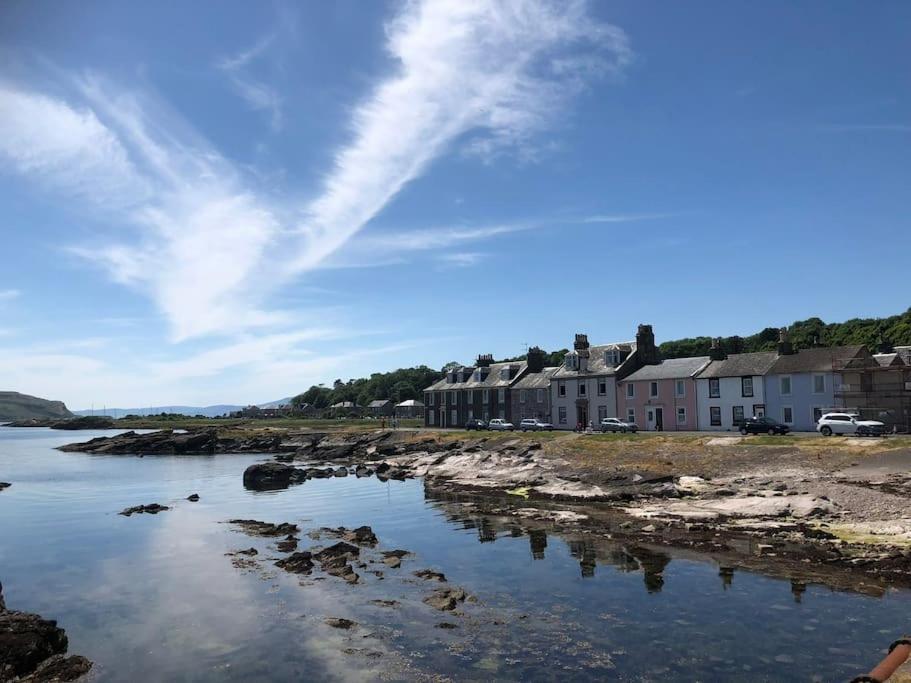 a group of houses on the shore of a body of water at Millport Beach Apartment, Crichton St, sea views in Millport