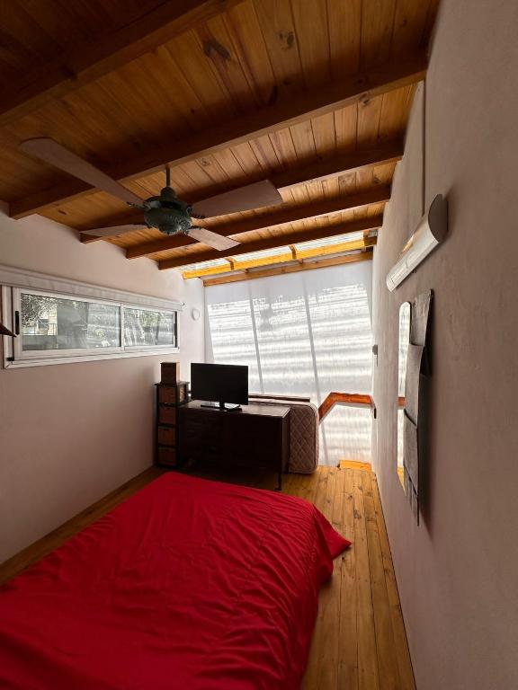 Habitación con cama roja y escritorio.  en Plumerillos aparte en Mar de las Pampas