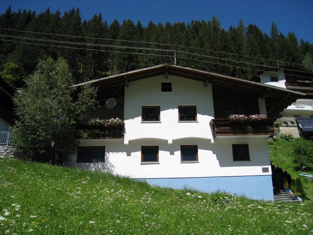 biały budynek z balkonem na wzgórzu w obiekcie Ferienhaus Monte Bianco w mieście Kappl