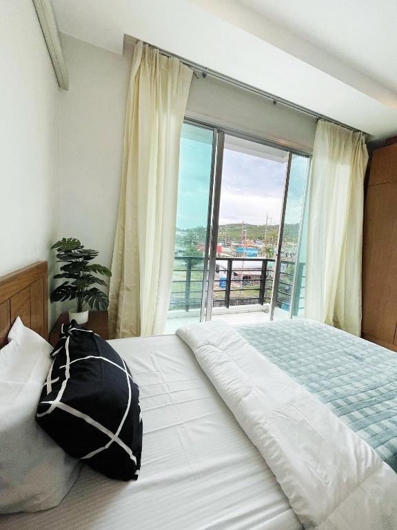 a bedroom with a bed and a large window at S303 Good Apartment Chalong Na-kok in Phuket Town