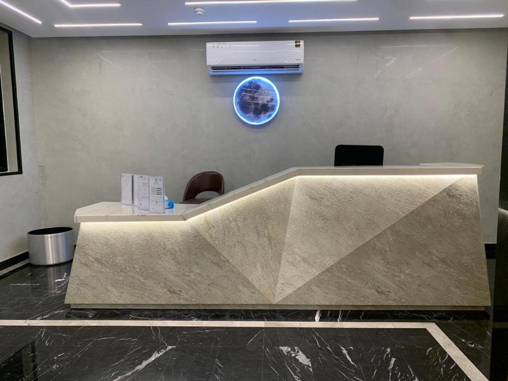 vestíbulo con un gran escritorio de hormigón con 2 sillas en قمة راحتي للشقق المخدومة Qimat Rahaity SERVICED APARTMENTS, en Yanbu