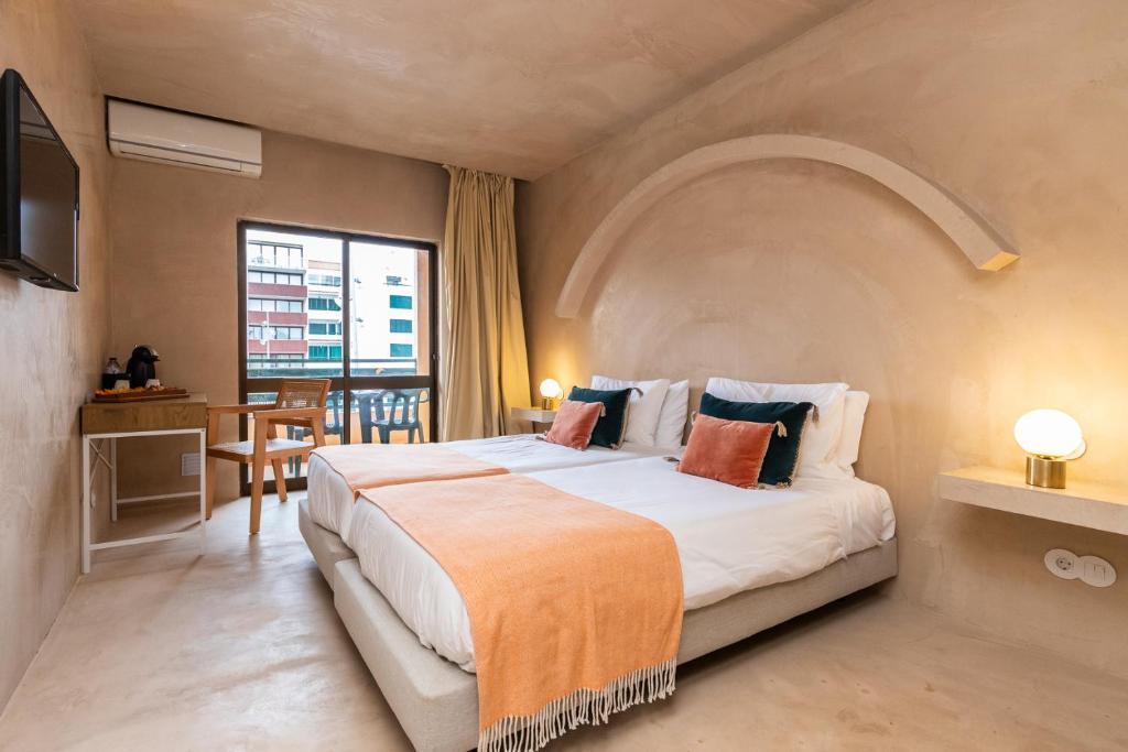 a bedroom with a large bed with an arched ceiling at Casablanca Unique Hotel in Monte Gordo