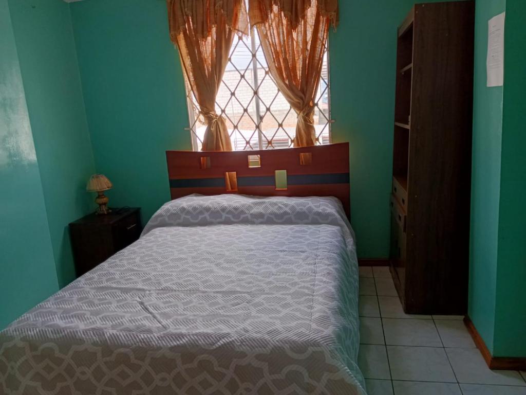 1 dormitorio con 1 cama grande y ventana en Acogedor departamento, en Loja