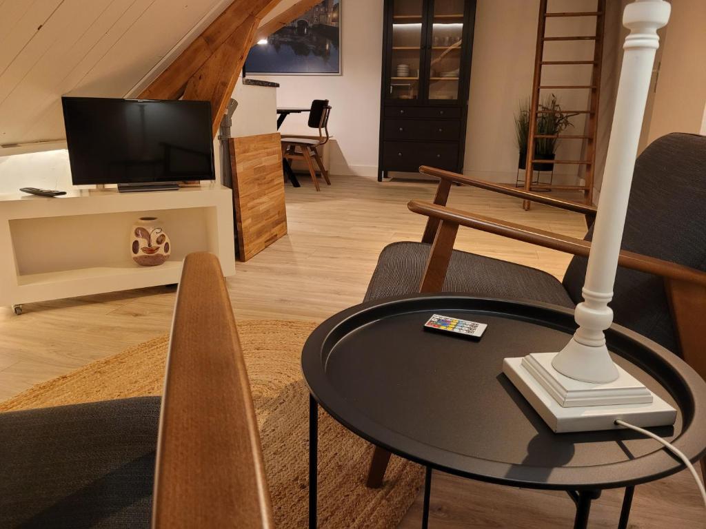 een woonkamer met een tafel en een televisie bij BakeryInn Amersfoort in Amersfoort