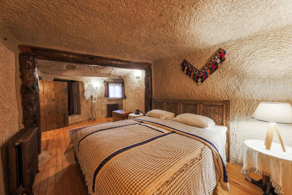 a bedroom with a bed and a butterfly on the wall at Cappadocia Cave Suites Adult Only in Goreme