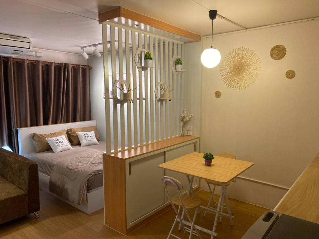 Ban Bang Phang的住宿－PTJ Style Condotel คอนโดเมืองทอง，一间卧室配有一张床、一张桌子和一张桌子