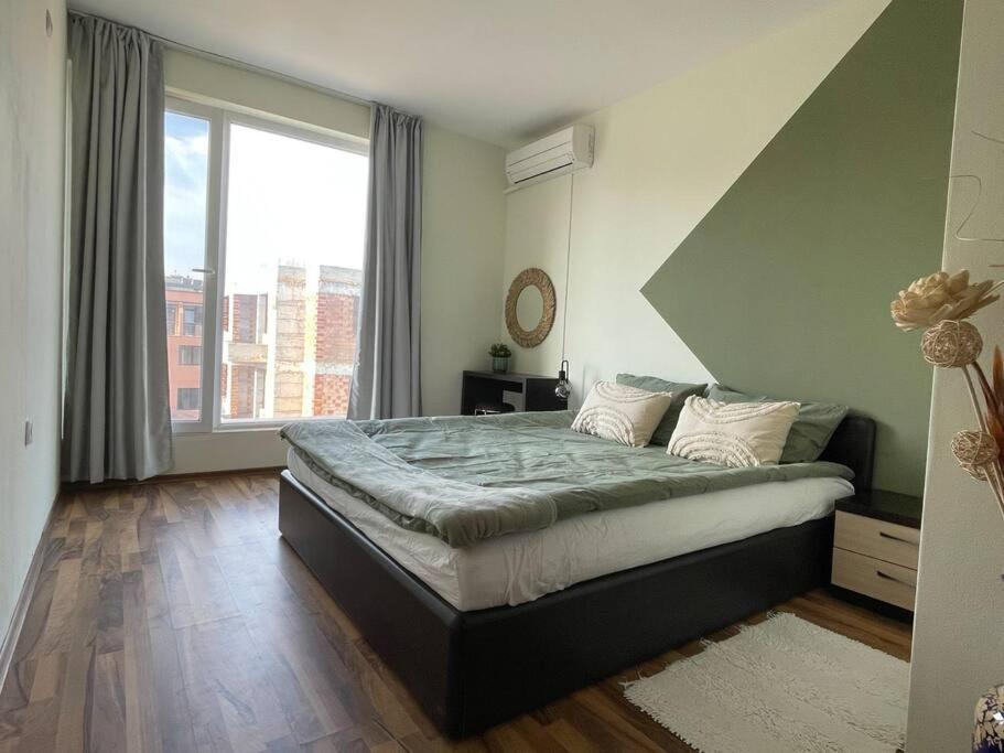 um quarto com uma cama grande e uma janela grande em Chic&Cozy Apartment in Nessebar em Nessebar