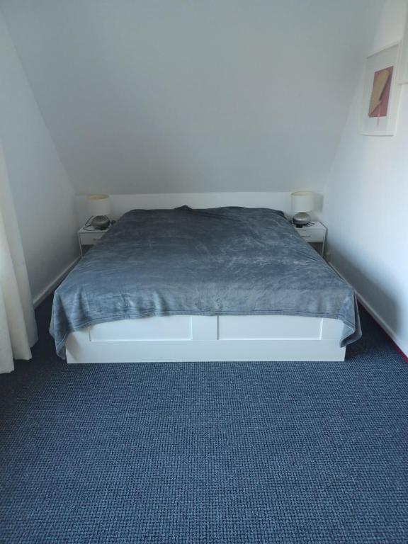 ハンブルクにあるFamilienzimmer HH-Schnelsenのベッドルーム1室(ベッド1台、グレーの毛布付)