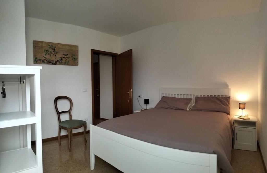 1 dormitorio con 1 cama grande y 1 silla en Agriturismo Le Crede 1930, en Portogruaro