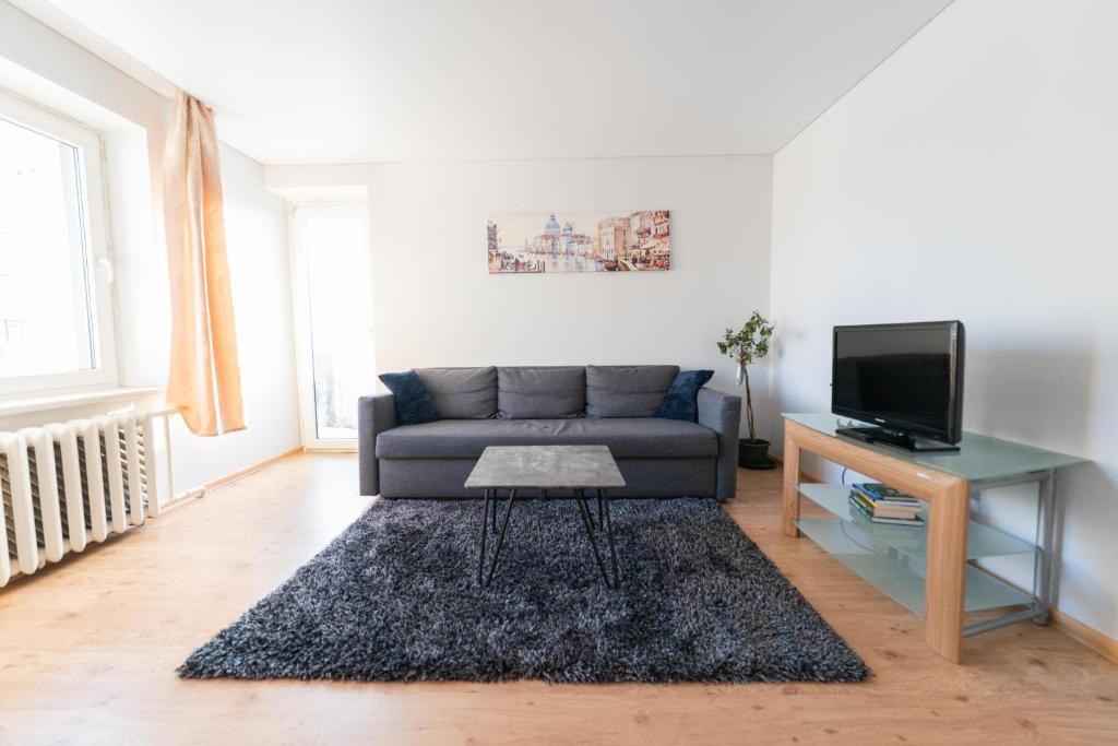 un soggiorno con divano e tavolo di Šeškinės 61 Spacious Cozy Apartment a Vilnius