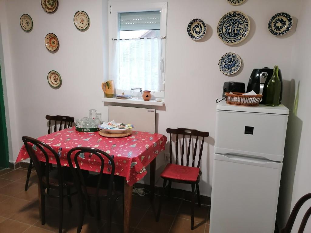 a kitchen with a table with chairs and plates on the wall at Berkenyés Vendégház in Zalalövő