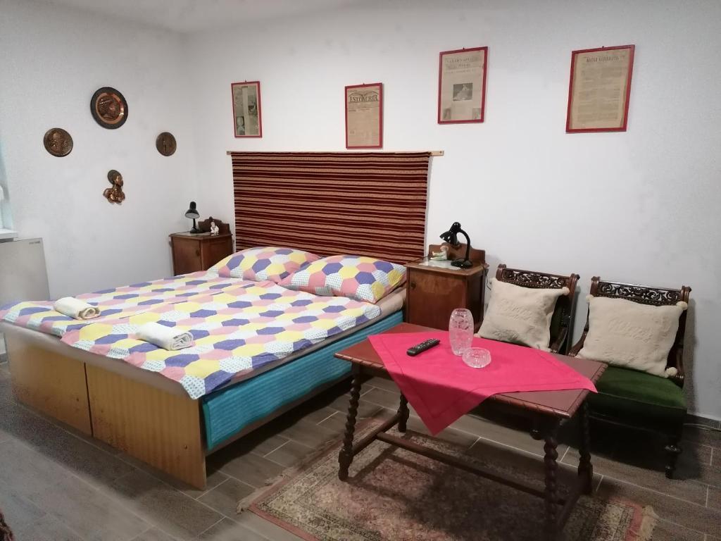a bedroom with a bed and a table and a couch at Berkenyés Vendégház in Zalalövő