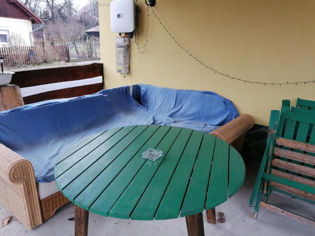 a green table and chairs in a patio at Berkenyés Vendégház in Zalalövő