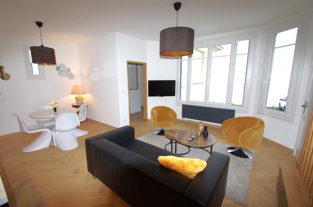 a living room with a couch and a table at Le Charmant in Tours