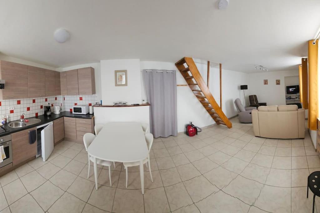 a kitchen with a white table and chairs in a room at Gîte le Carassin in Bouillon