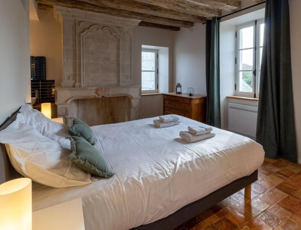 a bedroom with a large bed with two towels on it at Gîte Apolise in Saint-Rémy-la-Varenne