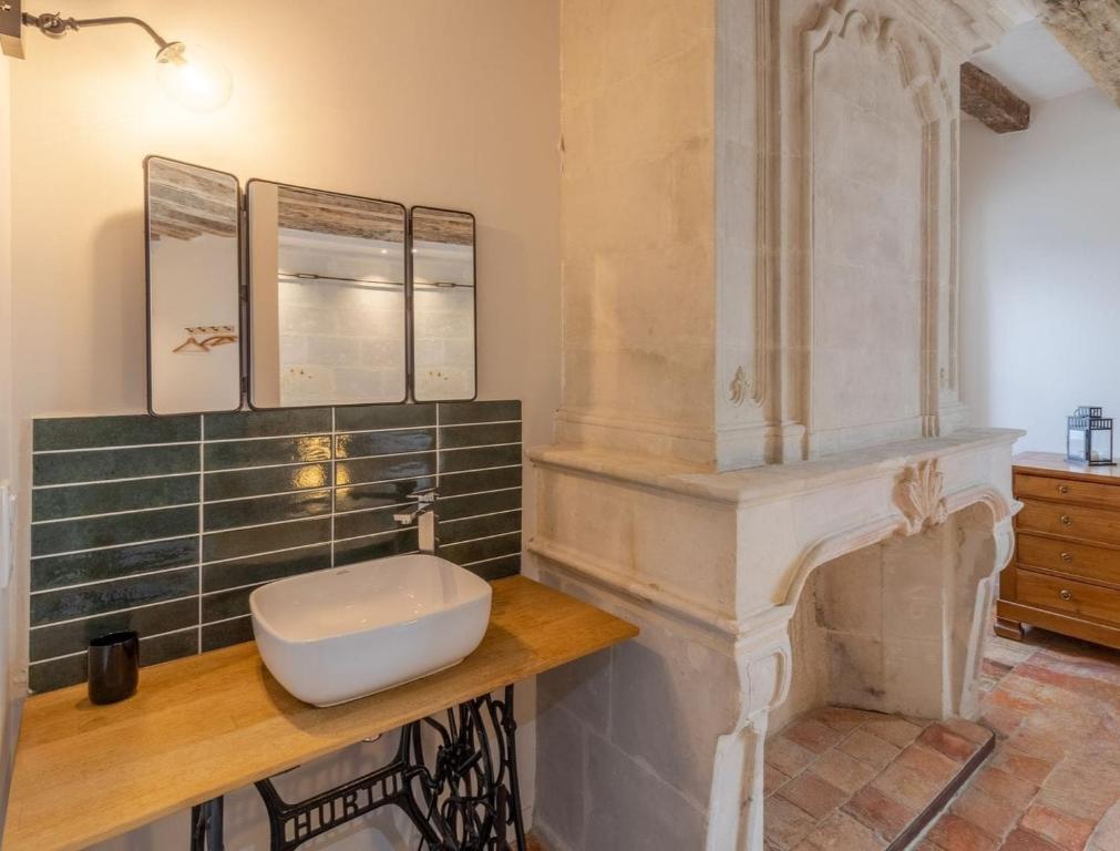 a bathroom with a sink on a wooden counter at Gîte Apolise in Saint-Rémy-la-Varenne