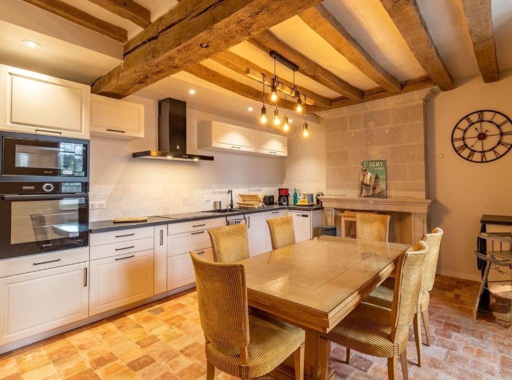 a kitchen with a wooden table and chairs in it at Gîte Apolise in Saint-Rémy-la-Varenne