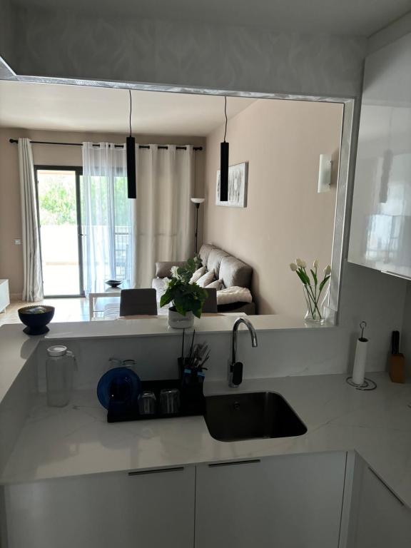 a kitchen with a sink and a living room at Apartamento Al-Alba Golf Resort Valle del Este in Vera