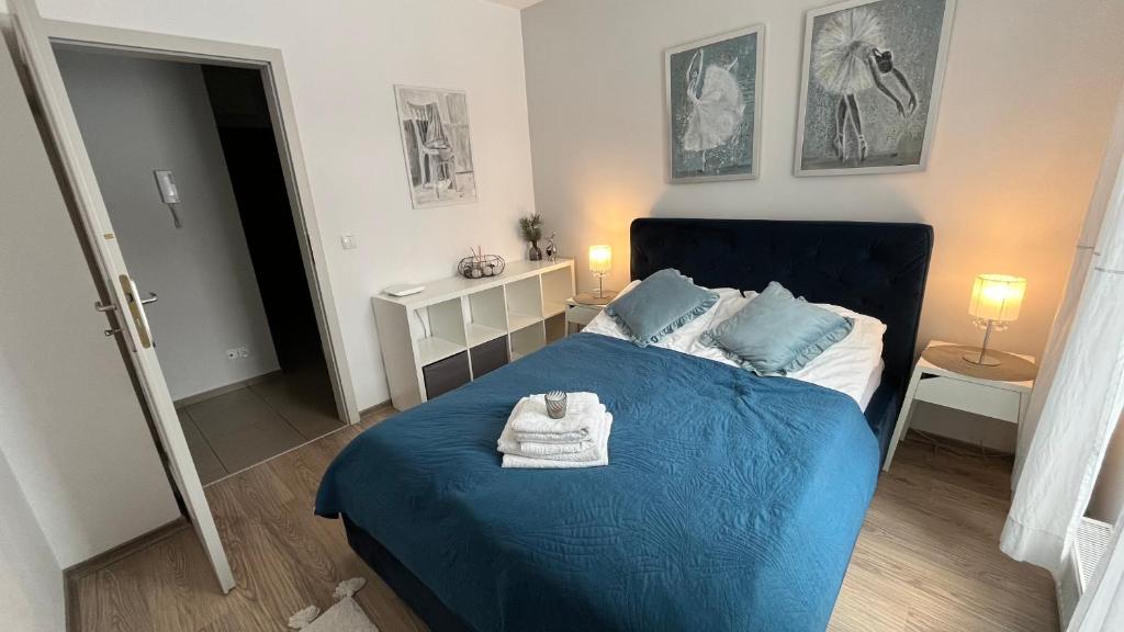 Un dormitorio con una cama azul con una toalla. en Apartament Kalina, en Lublin