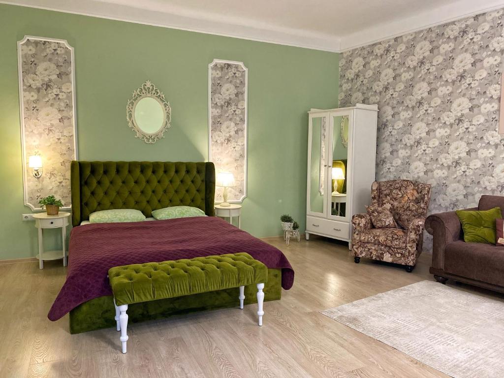 een slaapkamer met een bed, een bank en een stoel bij Edem Apartments in Lviv in Lviv