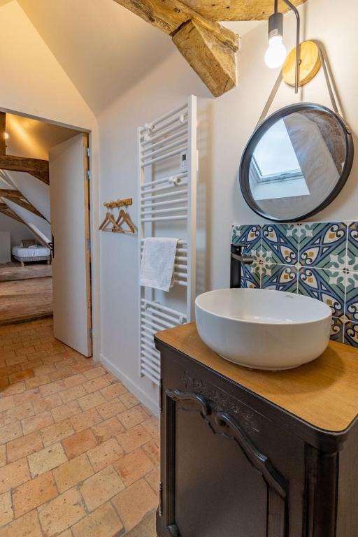 a bathroom with a sink and a mirror on a counter at Gîte Apolise in Saint-Rémy-la-Varenne