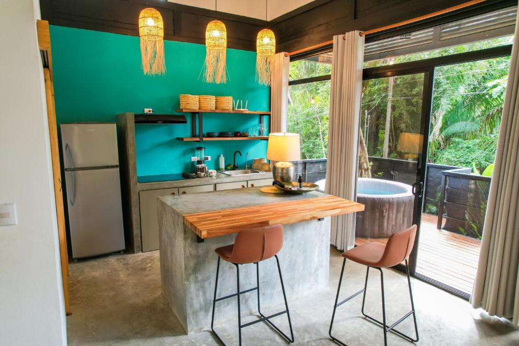 uma cozinha com um balcão com dois bancos e uma mesa em Casita Vinita em Nosara