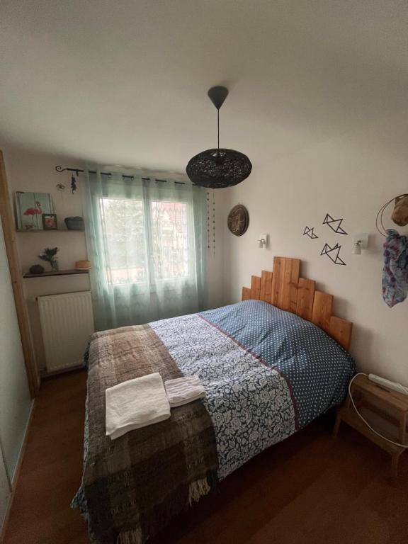 - une chambre avec un lit et une couette bleue dans l'établissement La cabane, à Fontaine