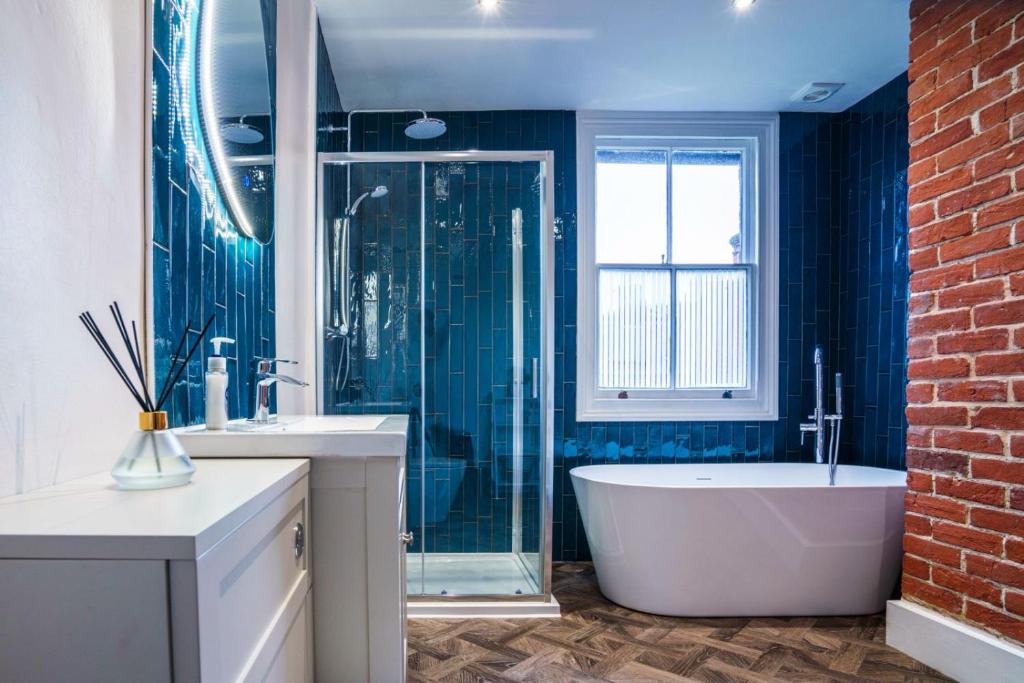 a bathroom with a tub and two sinks and a window at The Castle City Centre Apartment in Canterbury